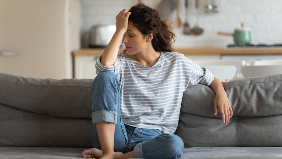 Exhausted,Frustrated,Young,Woman,Touching,Forehead,,Sitting,On,Couch,Alone,