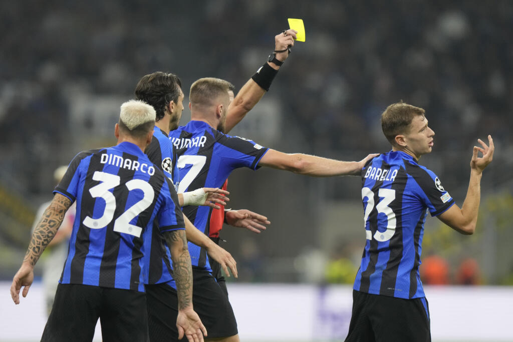EBE 57 Miláno - Na snímke vľavo v pozadí slovinský hlavný rozhodca Slavko Vinčič udeľuje žltú kartu, vpravo jej adresát a hráč Interu Nicola Barella, druhý sprava slovenský obranca Interu Milan Škriniar v zápase C-skupiny 3. kola skupinovej fázy Ligy majstrov vo futbale Inter Miláno - FC Barcelona v Miláne 4. októbra 2022. FOTO TASR/AP
Inter Milan's Nicolo Barella, right, reacts as he is shown a yellow card by referee Slavko Vincic during the Champions League group C soccer match between Inter