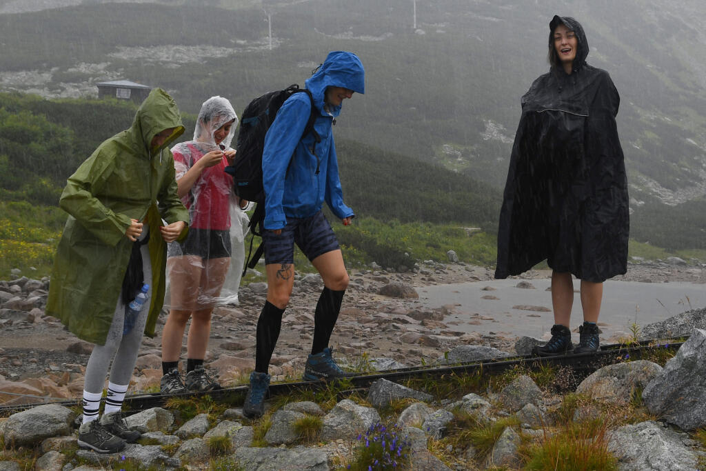 Niektorých turistov vo Vysokých Tatrách často od túr neodradí ani neisté počasie s predpokladom dažďa. Na snímke turistky sa napriek dažďu rozhodli pokračovať v túre zo Skalnatého plesa k Zelenému plesu cez Svišťovku. Tatranská Lomnica, 2. augusta 2021. FOTO TASR - Milan Kapusta