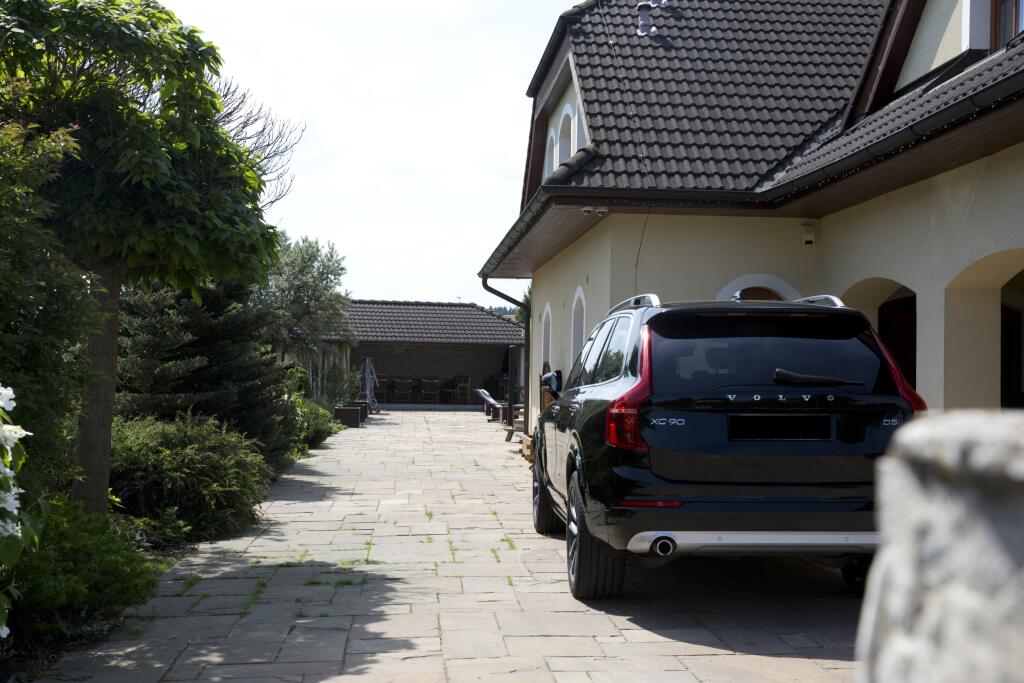 Dom je stále obývaný, čo naznačuje zaparkované veľké čierne auto.
