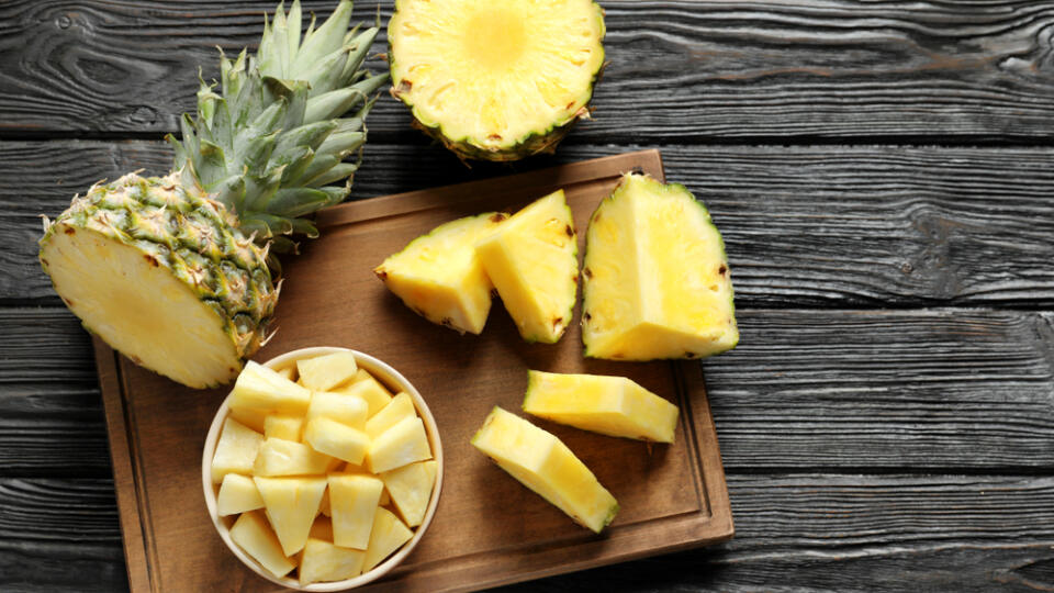 Wooden,Board,With,Fresh,Sliced,Pineapple,On,Table,,Top,View