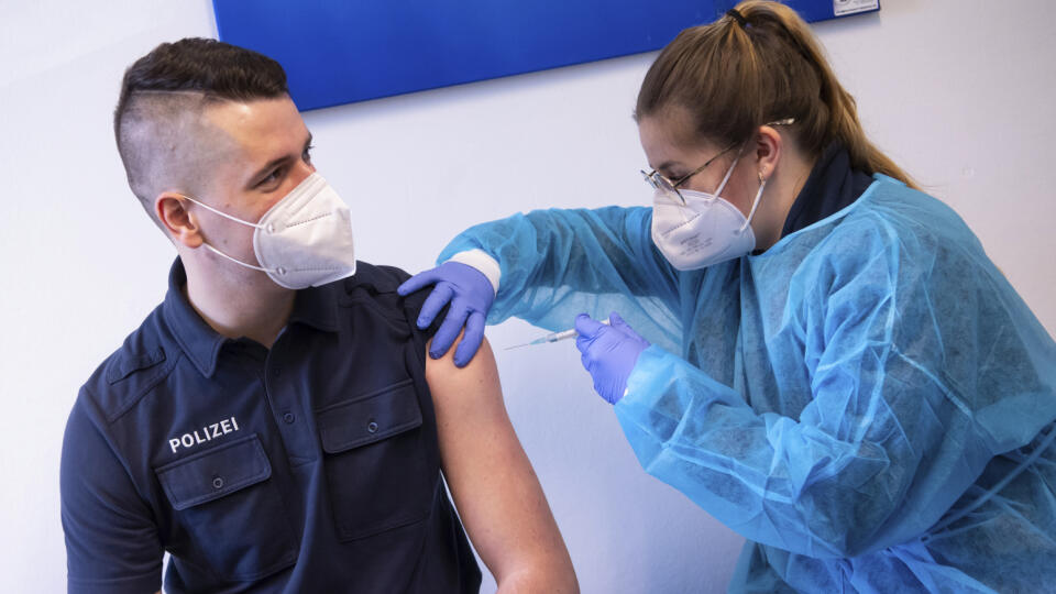Zdravotníčka podáva vakcínu proti ochoreniu COVID-19 od spoločnosti AstraZeneca policajtovi počas očkovania policajtov vo vakcinačnom centre v Mníchove. Nemecko nateraz stoplo očkovanie touto vakcínou.