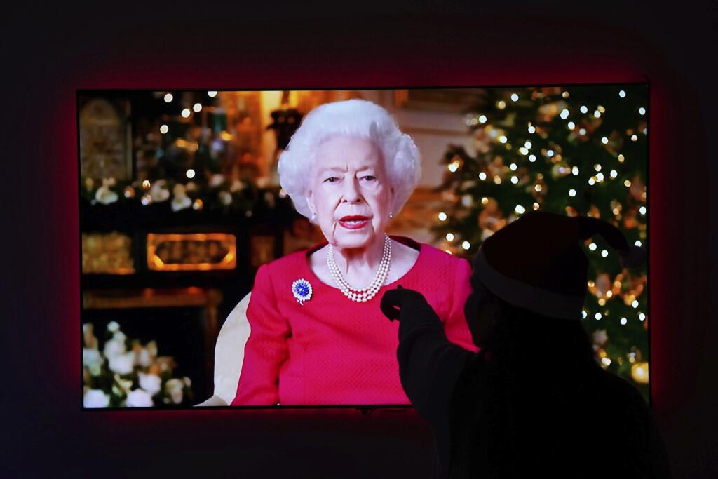 Dieťa ukazuje na televíznu obrazovku v Larbete počas tradičného televízneho vianočného príhovoru britskej kráľovnej Alžbety II. z Windsorského hrade v sobotu 25. decembra 2021.