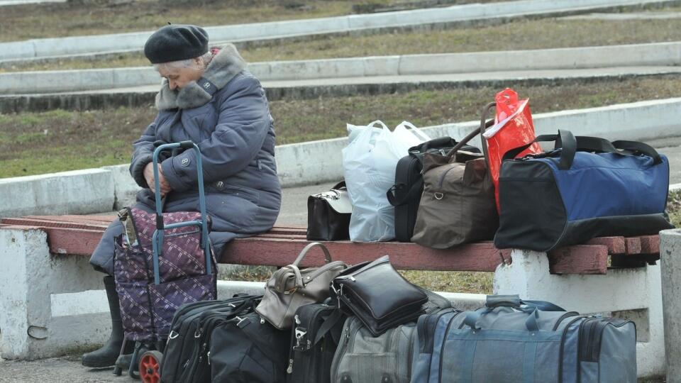 Na snímke staršia žena s batožinou počas evakuácie obyvateľov z Luhanskej oblasti 24. februára 2022.