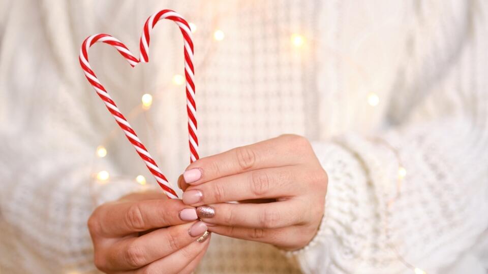 Close-up,Of,Women's,Hands,Holding,Candy,Canes,In,The,Form