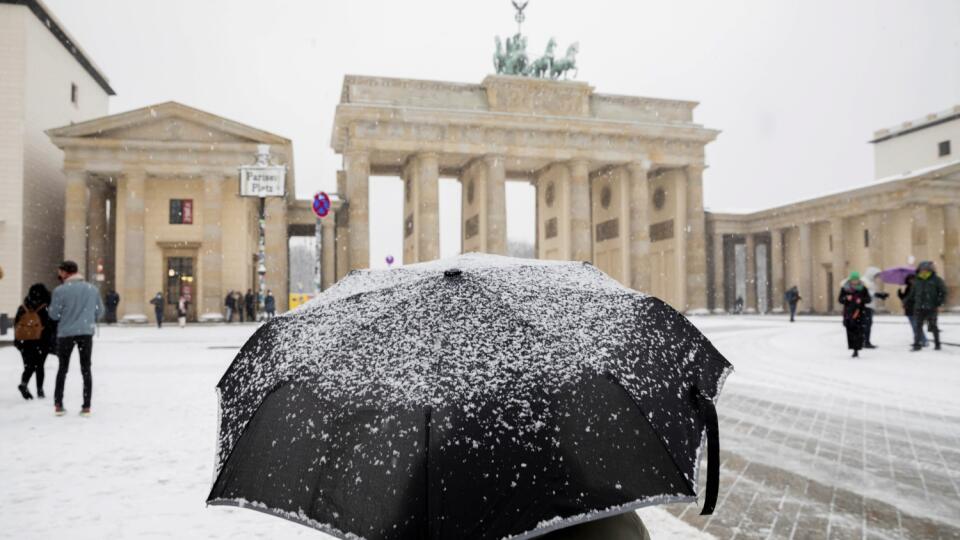 EBE 42 Berlín - Na snímke osoba s dáždnikom stojí pred Brandenburskou bránou v snežení v Berlíne 9. decembra 2021. FOTO TASR/AP
A person stands under an umbrella stands in the snow in front of the Brandenburg Gate, in Berlin, Thursday, Dec. 9, 2021. (Christoph Soeder/dpa via AP)