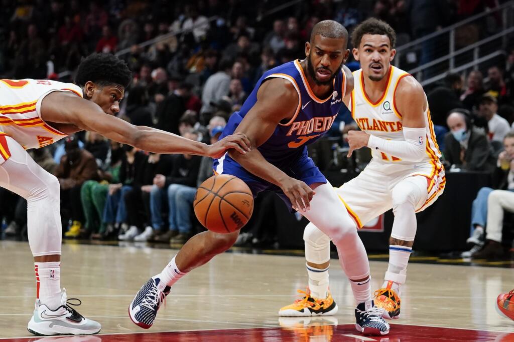 JB 3 Atlanta - Hráč Atlanty Hawks Trae Young (vpravo) bráni Chrisa Paula z Phoenixu Suns, vľavo sa naťahuje za loptou De'Andre Hunter z Atlanty v basketbalovom zápase zámorskej NBA v Atlante 3. februára 2022. FOTO TASR/AP
Phoenix Suns guard Chris Paul (3) drives between Atlanta Hawks' Trae Young (11) and De'Andre Hunter (12) during the first half of an NBA basketball game Thursday, Feb. 3, 2022, in Atlanta. (AP Photo/John Bazemore)