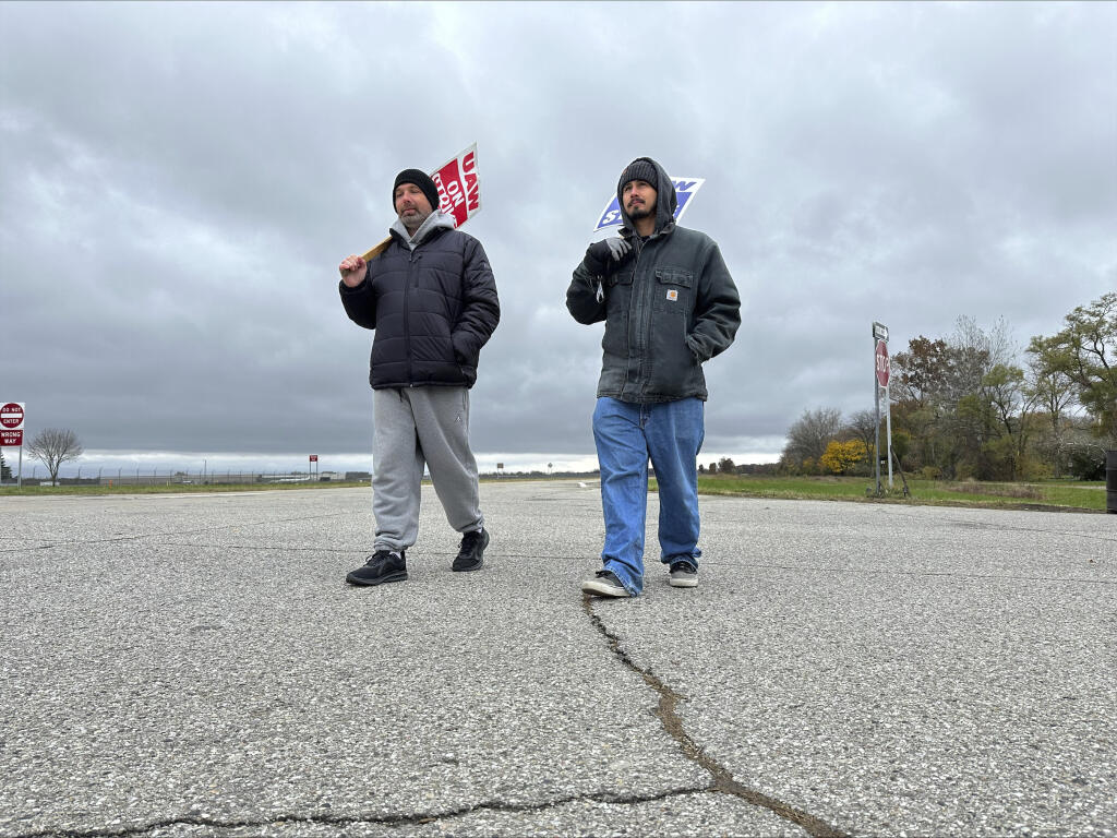Členovia United Auto Workers kráčajú pred závodom General Motors vo Van Buren Township v štáte Michigan.