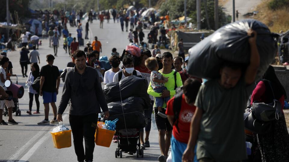 KK13 Lesbos - Migranti sa presúvajú so svojimi vecami z tábora Morie do mesta Mytilene na gréckom ostrove Lesbos 12. septembra 2020. Grécka polícia ostrove Lesbos spustila vo štvrtok operáciu, ktorej cieľom je presťahovať stovky migrantov bez prístrešia do provizórneho stanového tábora. Ide o obyvateľov preľudneného tábora Moria, ktorý minulý týždeň zničil rozsiahly požiar. FOTO TASR/AP
Migrants carry their belongings as they flee a road leading from Moria to the capital of Mytilene, on the nor