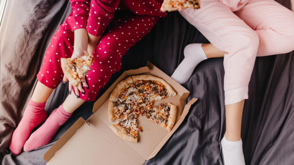 Overhead,Portrait,Of,Two,Girls,In,Pajamas,Sitting,On,Bed