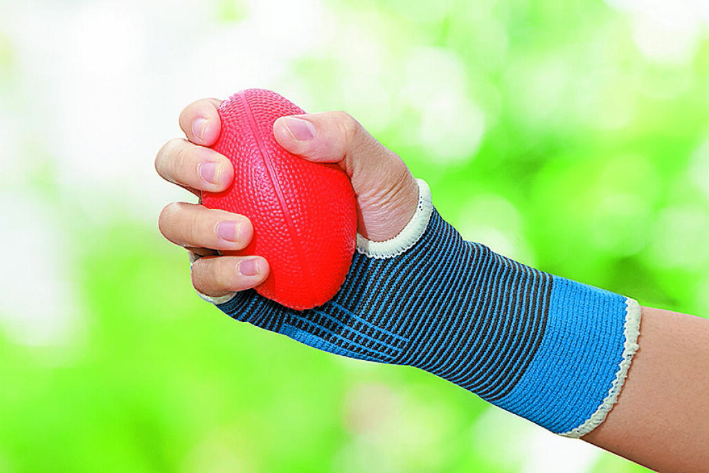 Hand exercise. Squeezing exercise. Balls in womans hand. Tie hands to balls.