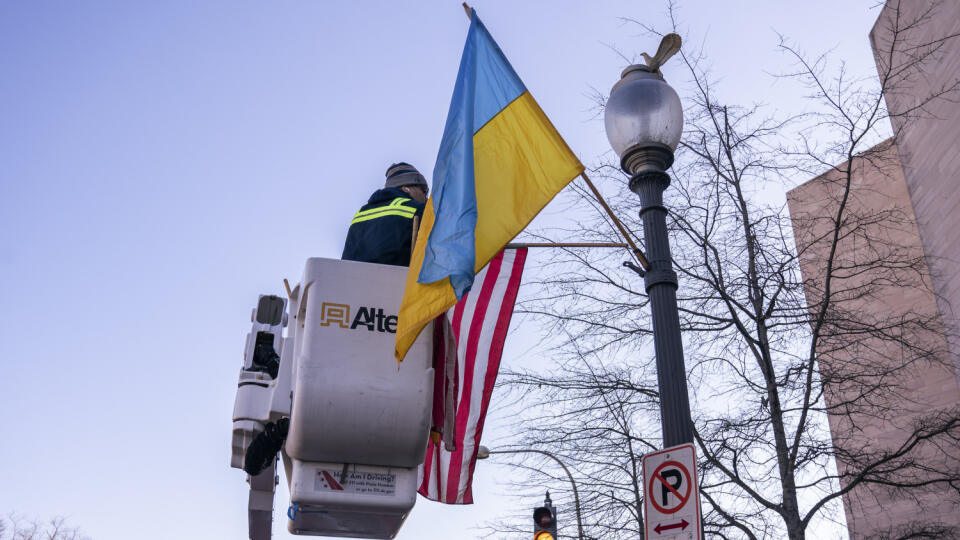 Pracovníci upevňujú americkú a ukrajinskú zástavu na Pennsylvania Avenue pri budove amerického Kapitolu pred návštevou ukrajinského prezidenta Volodymyra Zelenského v Bielom dome vo Washingtone 21. decembra 2022. Táto zahraničná cesta, jeho prvá od začiatku ruskej invázie na Ukrajinu, však závisí od bezpečnostnej situácie.