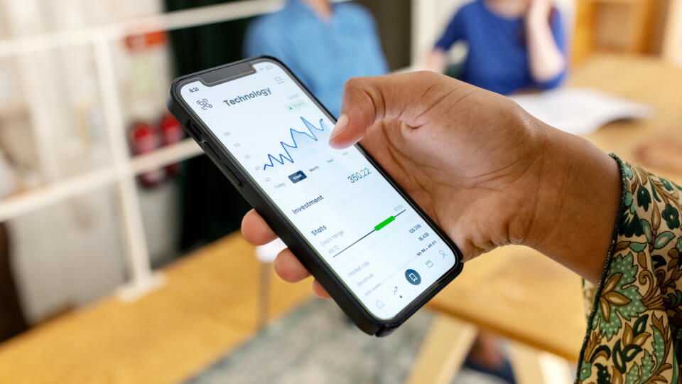 Close-up of woman trading stock online on mobile phone
