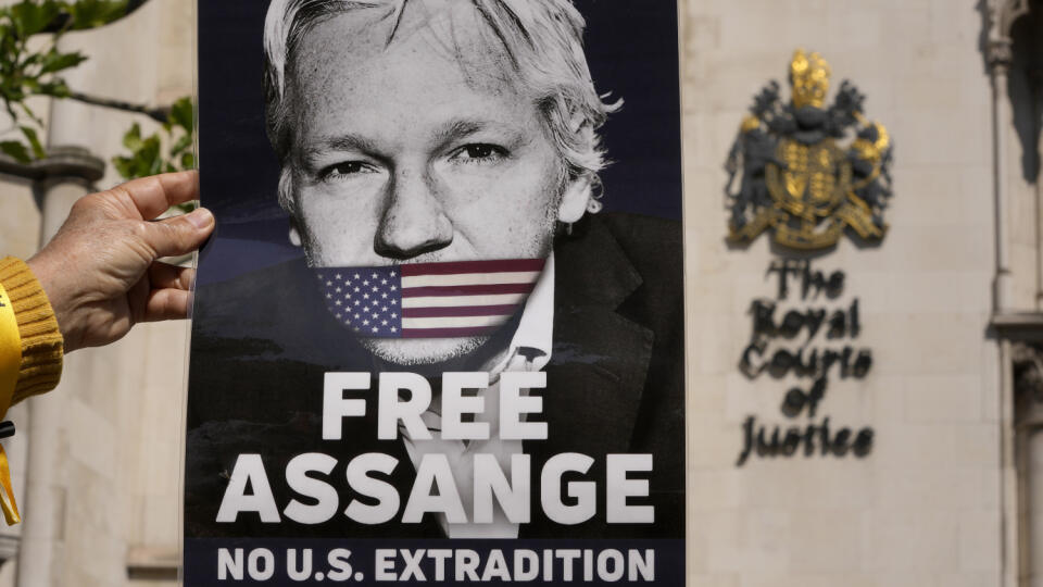 WA 4 Londýn - Demonštrant číta nvoiny pred  budovou Vrchného súdu v Londýne v pondelok 20. mája 2024. Zakladateľ servera WikiLeaks Julian Assange sa môže odvolať proti vydaniu do Spojených štátov, rozhodol v pondelok Vrchný súd v Londýne.Washington žiada o vydanie Assangea do USA za údajné sprisahanie po tom, ako zverejnil státisíce uniknutých tajných dokumentov týkajúcich sa aktivít Spojených štátov okolo vojen v Afganistane a Iraku.  Vrchní sudcovia londýnskeho súdu v pondelkovom verdikte uvie