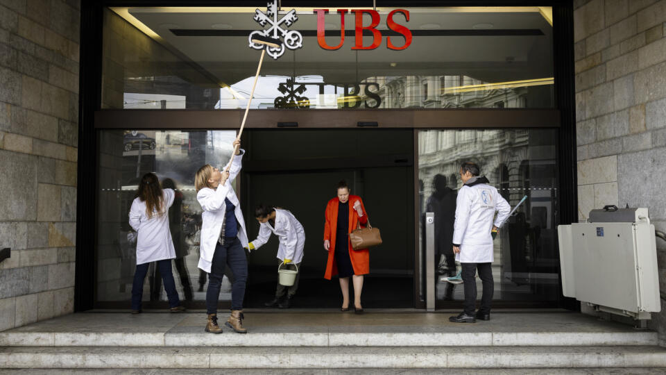 Aktivisti Scientist Rebellion symbolicky čistia vchod do švajčiarskej banky UBS na Paradeplatz počas protestu proti investíciám do fosílnych palív vo švajčiarskom Zürichu.