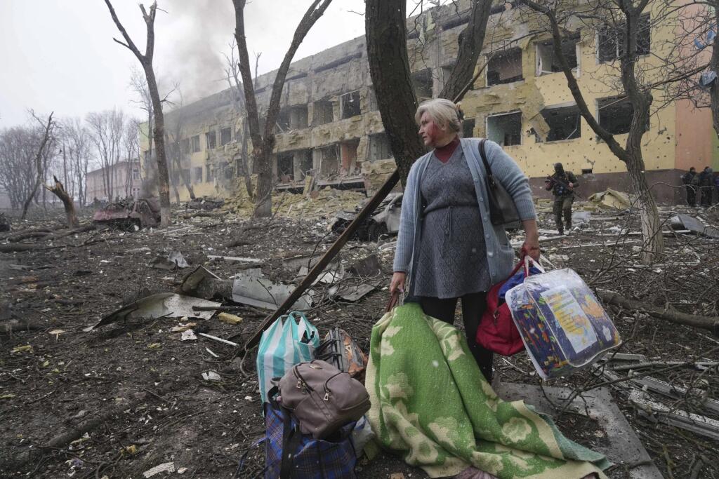 KK46 Mariupol - Na snímke žena pred budovou zničenej budove pôrodnice po ostreľovaní v Mariupole počas štrnásteho dňa ruskej invázie na Ukrajine v stredu 9. marca 2022. Ruská armáda pri stredajšom ostreľovaní ukrajinského mesta Mariupol zasiahla a zničila detskú nemocnicu a pôrodnicu, tvrdia miestni činitelia aj ukrajinský prezident Volodymyr Zelenskyj. TASR túto informáciu prevzala zo stanice Sky News. FOTO TASR/AP  

A woman walks outside the damaged by shelling maternity hospital in Mariupol,