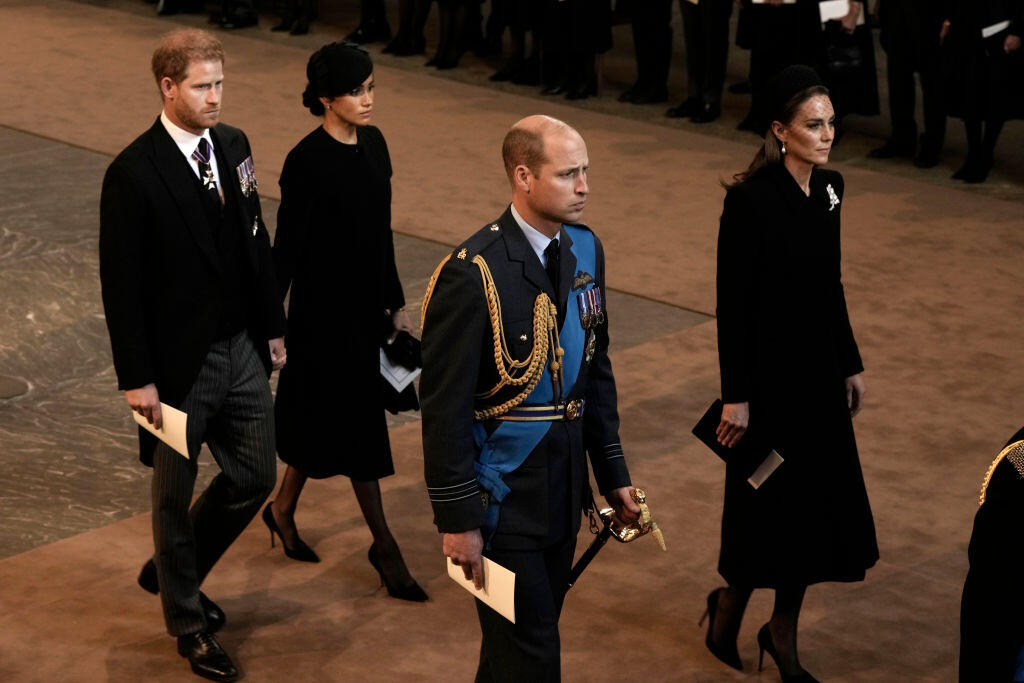 Na snímke je zobrazená Meghan s Harrym a tiež princezná Kate s princom Williamom počas pohrebu.