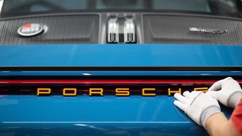 KK5 archív Zuffenhausen - Na archívnej snímke z 6. marca 2025 zamestnanec spoločnosti Porsche lepí nápis na Porsche 911 S/T v nemeckom Zuffenhausene. Výkonný riaditeľ spoločnosti Porsche Oliver Blume pripravuje zamestnancov výrobcu športových automobilov na ďalšie kolo tvrdých úsporných opatrení. „Situácia je naďalej vážna a priemysel sa vyvíja veľmi dynamicky,“ napísal Blume v liste zamestnancom. FOTO TASR/DPA
ARCHIV - 06.03.2025, Baden-WĂĽrttemberg, Zuffenhausen: Ein Mitarbeiter der Porsche AG