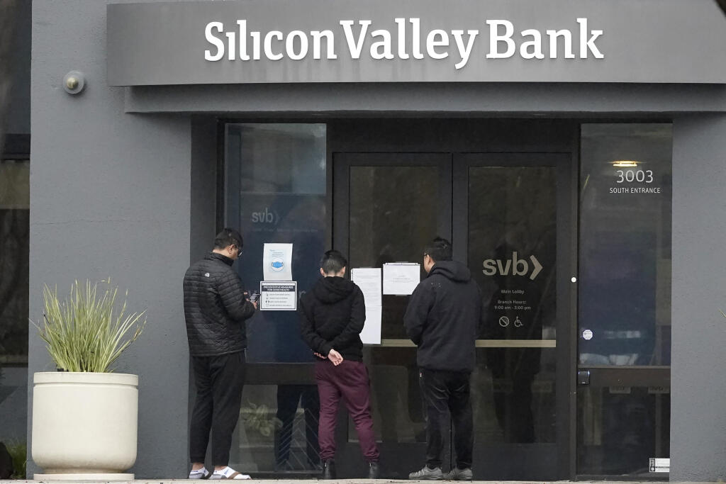 WA 40 Santa Clara - Ľudia si čítajú oznam pred vchodom do banky Silicon Valley Bank (SVB) v kalifornskej Santa Clare v piatok 10. marca 2023. Po skončení desaťročnej éry lacných peňazí sa v globálnom finančnom systéme objavujú trhliny. Niektorí investori sa tak obávajú 