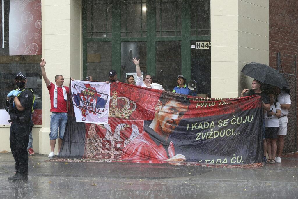 KK7 Melbourne - Na snímke priaznivci srbského tenistu Novaka Djokoviča protestujú v daždi pred budovou zariadenia pre imigrantov, v ktorom sa pravdepodobne nachádza srbský tenista Novak Djokovič 7. januára 2022 v Melbourne. Srbský tenista Novak Djokovič sa obrátil na súd v Melbourne v snahe zvrátiť rozhodnutie o deportácii z Austrálie. Noc trávil v detenčnom zariadení pre imigrantov, súd predbežným opatrením zabránil jeho okamžitému vyhosteniu. Prípad bude pokračovať v pondelok o 10.00 h miestne