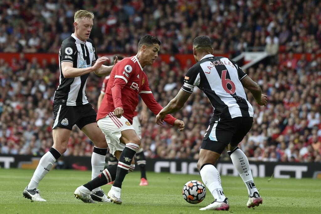 KK61 Manchester - Futbalista Manchestru United Cristiano Ronaldo (uprostred) a hráči Newcastlu United Sean Longstaff a Jamaal Lascelles (vpravo) počas zápasu 4. kola anglickej Premier League Manchester United - Newcastle United 11. septembra 2021 v Manchestri. FOTO TASR/AP
Manchester United's Cristiano Ronaldo drives the ball between Newcastle's Sean Longstaff and Jamaal Lascelles, right, during the English Premier League soccer match between Manchester United and Newcastle United at Old Traffor