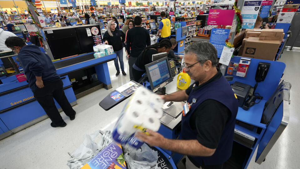 FILE - In this Nov. 9, 2018, file photo Walmart associate Javaid Vohar, right, checks out customers at a Walmart Supercenter in Houston. Walmart Inc. reports earnings on Thursday, May 16, 2019. (AP Photo/David J. Phillip, File)