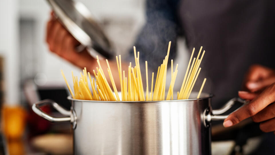 Closeup,Of,Spaghetti,In,Pot,On,Stove.,Woman,Holding,Pot