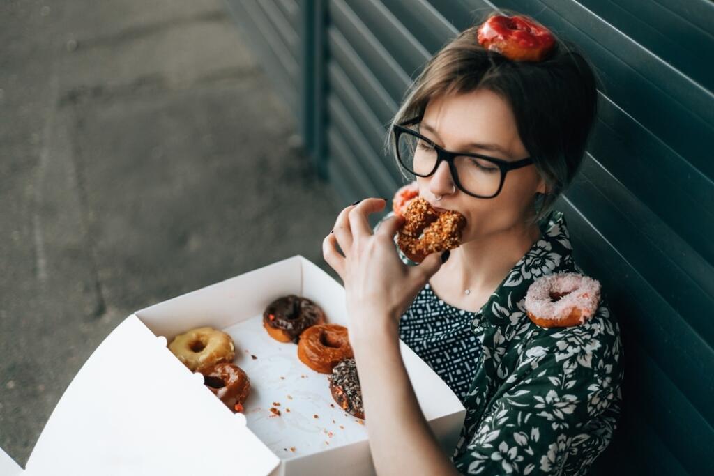 A,Young,Attractive,Woman,Covered,Herself,With,Donuts,And,Eats