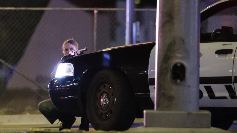 WA 2 Las Vegas - Policajtka sa schováva za autom počas streľby, ku ktorej došlo v meste Las Vegas v americkom štáte Nevada, 2. októbra 2017. Muža, ktorý zastrelil v Las Vegas najmenej 50 ľudí a ďalších minimálne 200 osôb zranil, polícia identifikovala ako 64-ročného belocha Stephena Paddocka. Lasvegaský šerif Joe Lombardo predtým uviedol, že Paddock, ktorý sa nachádzal na 32. poschodí hotela Mandalay Bay, spustil v nedeľu o 22.08 h miestneho času (dnes 09.08 SELČ) paľbu z automatickej zbrane na