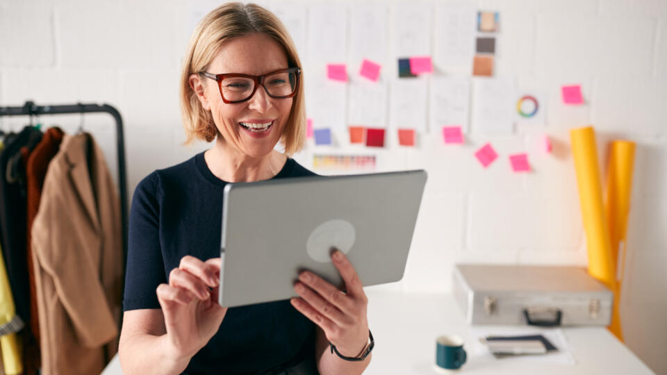 Mature,Businesswoman,Using,Tablet,Computer,In,Studio,Of,Start,Up