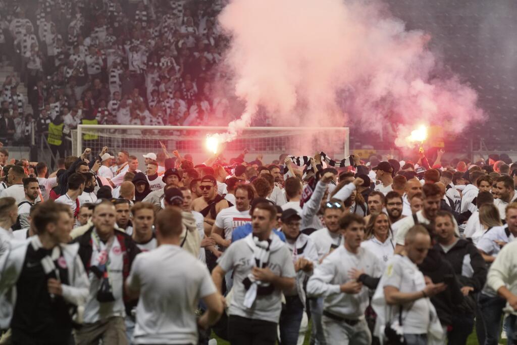 Fanúšikovia Frankfurtu oslavujú na ihrisku s dymovnicami po tom, ako naň vtrhli po postupe do finále v odvete semifinále Európskej ligy Eintracht Frankfurt - West Ham United vo Frankfurte 5. mája 2022.