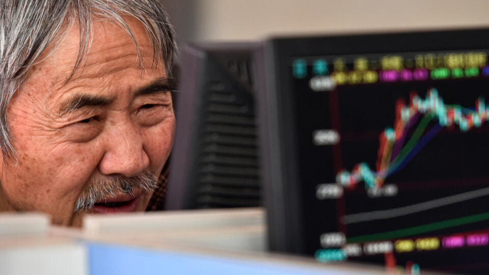 A trader watches the Shanghai Composite Index on a monitor