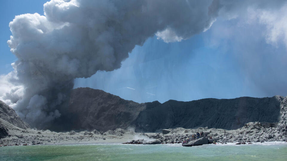 Na snímke z 9. decembra 2019 skupina turistov čaká na evakuáciu po erupcii sopky na ostrove White Island na Novom Zélande.