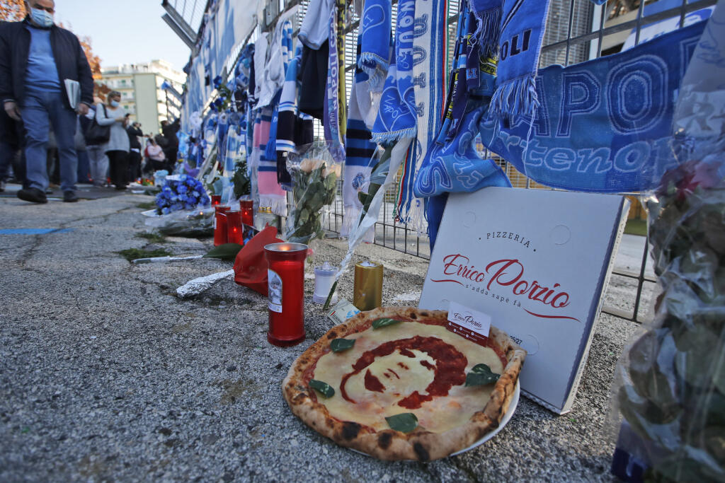 KK35 Neapol - Na snímke pizza s tvárou argentínskej futbalovej legendy Diega Maradonu je položená pred štadiónom Sao Paulo v Neapole 26. novembra 2020. Diego Maradona zomrel v stredu 25. novembra vo veku 60 rokov. Potvrdil to hovorca jeho rodiny. Podľa argentínskych médií bolo príčinou úmrtia zlyhanie srdca. Majster sveta z roku 1986 v Mexiku a vicemajster sveta z roku 1990 v Taliansku zomrel podľa denníka Clarin v stredu ráno miestneho času 25. novembra 2020 v argentínskom meste Tigre. Prezide