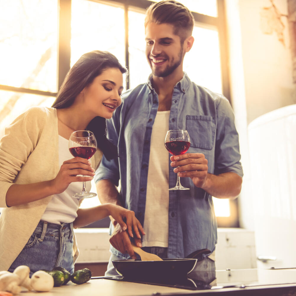 Beautiful,Young,Couple,Is,Drinking,Wine,And,Smiling,While,Cooking
