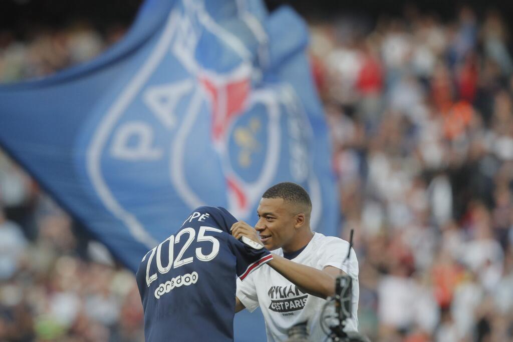 Na snímke francúzsky futbalista Kylian Mbappe z Paríža St. Germain drží dres s číslom 2025 oznamujúcim podpis novej trojročnej zmluvy pred zápasom 38. kola francúzskej Ligue 1 Paríž St. Germain - FC Metz v Paríži v sobotu 21. mája 2022. FOTO TASR/AP