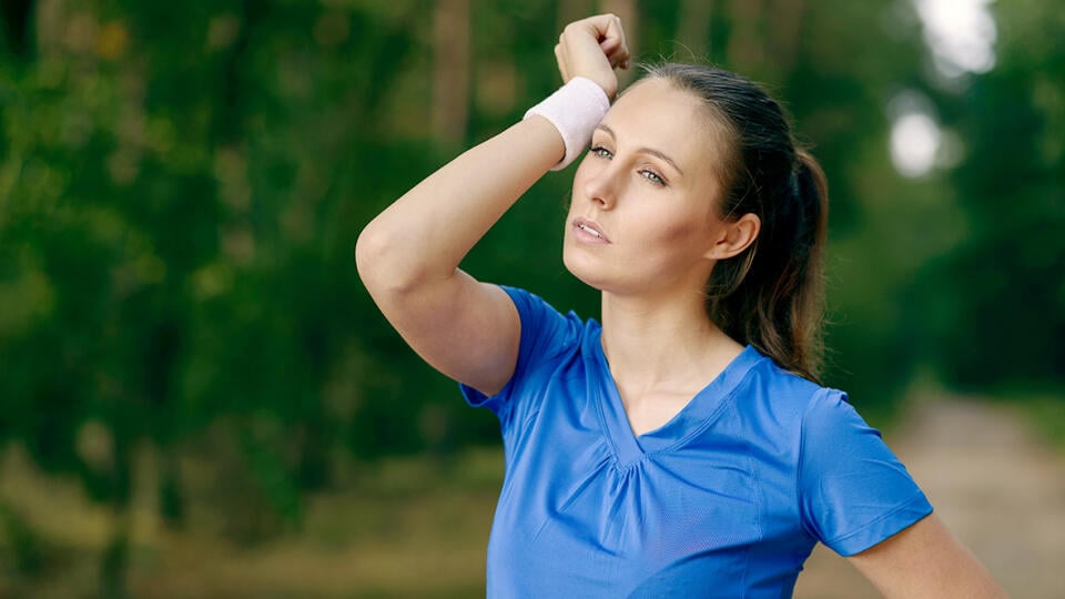 Woman,Athlete,Wiping,Sweat,From,Her,Forehead,Onto,Her,Wristband