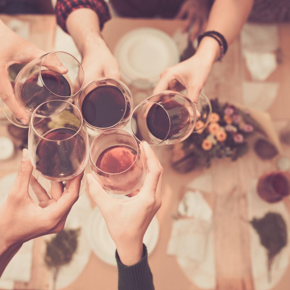 Friend clinking glasses above dinner table