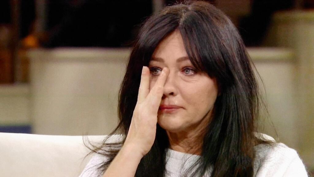 18 February 2016 - Los Angeles - USA
**** STRICTLY NOT AVAILABLE FOR USA ***
Shannen Dhoerty wipes away tears as she reveals she can't get pregnant due to breast cancer treatment on The Dr Oz Show. The Beverly Hills 90210 actress broke down crying as she spoke out about the problems she is facing after being diagnosed with cancer. The star can't have children with husband Kurt Iswarienko, who was sitting in the audience for support. She revealed she learned she had cancer after discovering a l