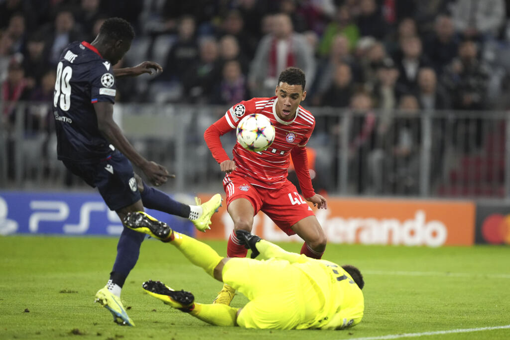 EBE 39 Mníchov - Na snímke vpravo dole slovenský brankár Plzne Marián Tvrdoň, uprostred hráč Bayernu Jamal Musiala a vľavo hráč Plzne Modou N'Diaye v zápase C-skupiny 3. kola skupinovej fázy Ligy majstrov vo futbale Bayern Mníchov - Viktoria Plzeň v Mníchove 4. októbra 2022. FOTO TASR/AP
Bayern's Jamal Musiala, center, Plzen's Modou N'Diaye, left, and Plzen's goalkeeper Marian Tvrdon challenge for the ball during the Champions League group C soccer match between Bayern Munich and Viktoria Pl