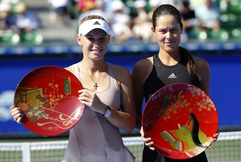 Ana Ivanovic of Serbia, right, and Caroline Wozniacki of Denmark pose for photographers after Ivanovic beat Wozniacki in their final to win the of the Pan Pacific Open Tennis tournament in Tokyo Sunday, Sept. 21, 2014. (AP Photo/Shizuo Kambayashi)