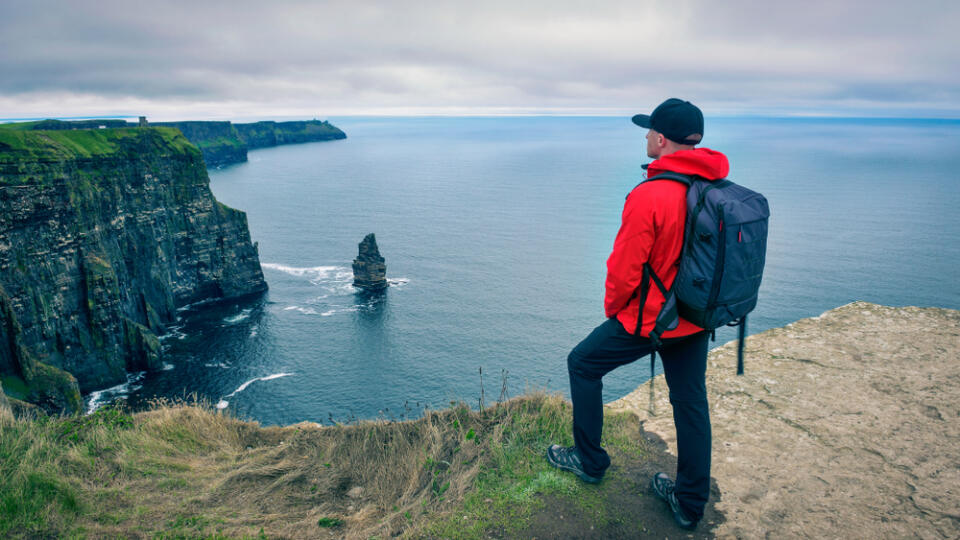 Young,Hiker,With,A,Backpack,Standing,At,The,Cliffs,Of