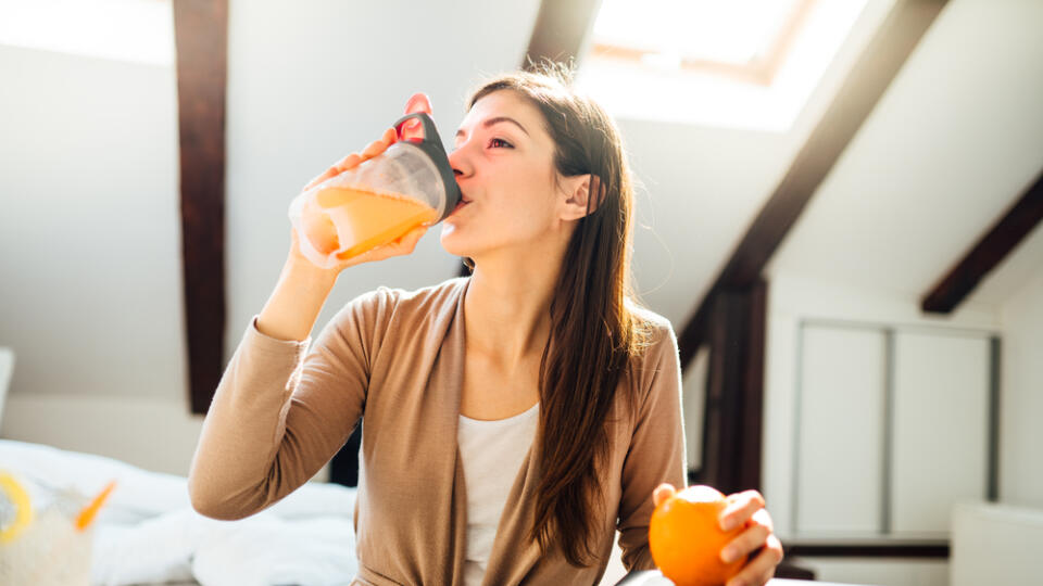 Woman,In,Home,Office,Drinking,Orange,Flavored,Amino,Acid,Vitamin