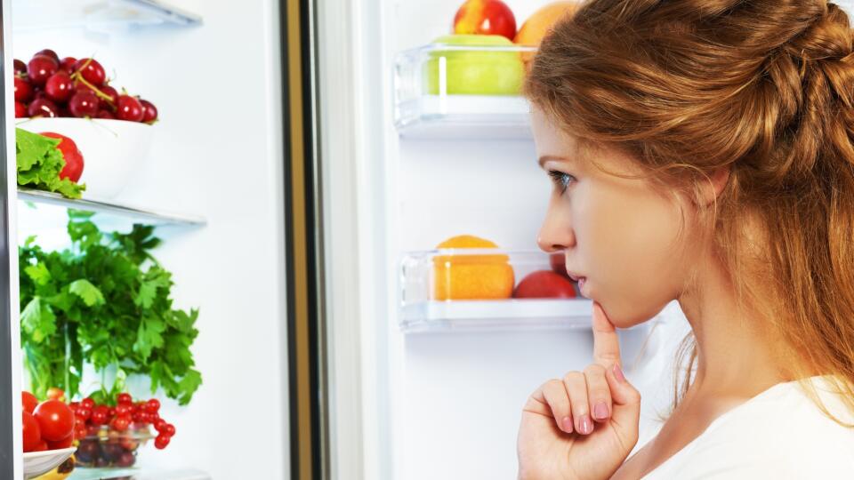 Happy woman and open refrigerator with fruits, vegetables