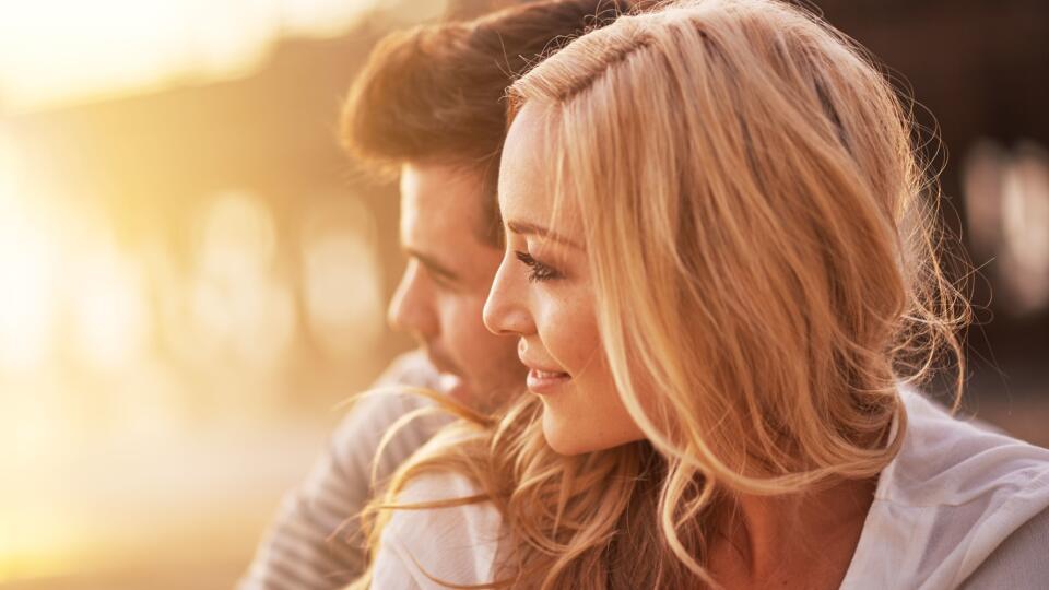 pretty girl cuddling with boyfriend on beach at santa monica