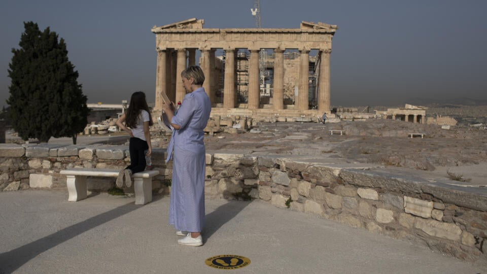KK27 Atény - Návštevníci stoja pred starovekým chrámom Parthenónom 18. mája 2020 v Aténach. Grécko v pondelok opäť otvorilo všetky archeologické pamiatky - vrátane aténskej Akropoly -, ktoré boli v dôsledku koronavírusovej pandémie dva mesiace uzavreté. FOTO TASR/AP
Visitors stand in front of the ancient Parthenon temple at the Acropolis hill of Athens, on Monday, May 18, 2020. Greece reopened the Acropolis in Athens and other ancient sites Monday, along with high schools, shopping malls, and ma
