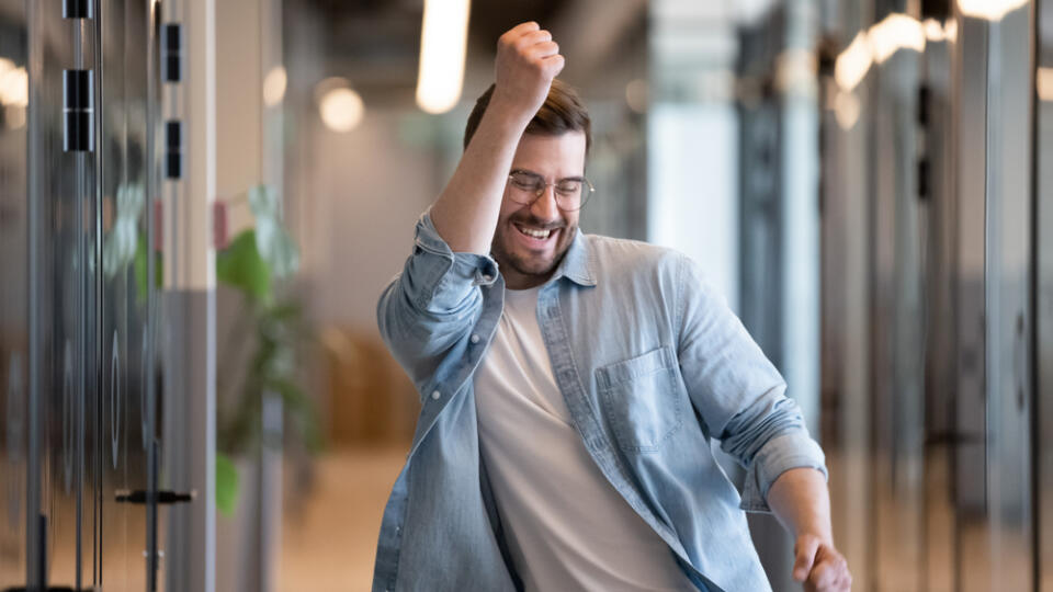 Ecstatic,Excited,Male,Winner,Dancing,In,Office,Hallway,Laughing,Celebrating