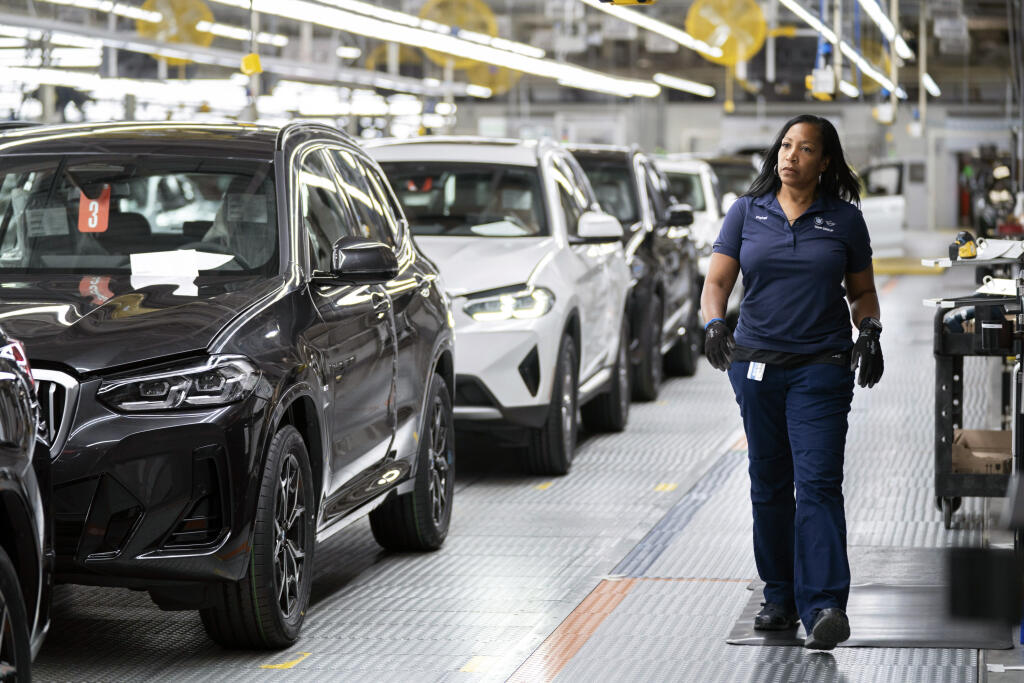 KK37 Greer - Na snímke zamestnankyňa kráča vo výrobnom závode automobilky BMW v Spartanburgu v Južnej Karolíne 19. októbra 2022. BMW investuje v USA do výroby elektromobilov a batérií celkovo 1,7 miliardy USD (1,74 miliardy eur). Ohlásená investícia zahŕňa 1 miliardu USD do prípravy produkcie elektromobilov v existujúcom závode automobilky v Spartanburgu v Južnej Karolíne. FOTO TASR/AP
FILE - An employee works in the X3, X45 assembly hall at the BMW Spartanburg plant in Greer, S.C., Oct. 19, 202