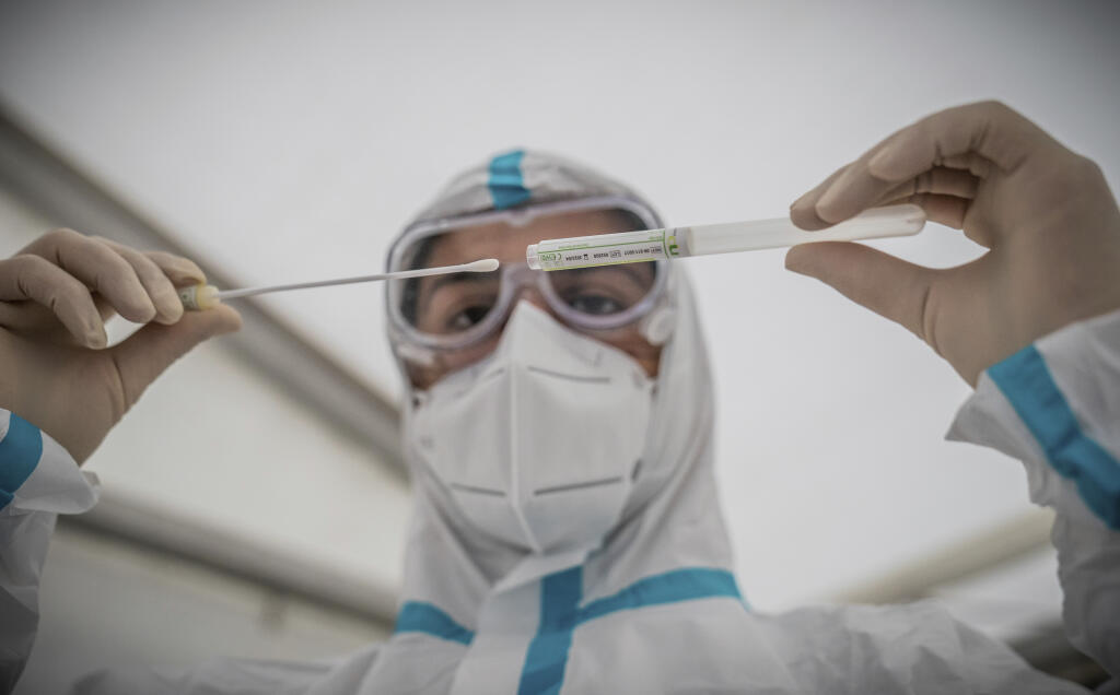 KK12 Berlín - Na snímke zdravotná pracovníčka vkladá tyčinku do tuby po odobratí vzorky na PCR test na ochorenie Covid-19 v testovacom centre na Covid-19 v Berlíne 14. októbra 2020.  Od začiatku pandémie zaznamenali v Nemecku podľa údajov RKI prinajmenšom 341.223 potvrdených prípadov nákazy novým druhom koronavírusu a 9710 súvisiacich úmrtí, z ktorých 33 pribudlo za posledný deň. Z nákazy sa tam dosiaľ vyliečilo približne 284.600 ľudí. FOTO TASR/AP
AA member of the medical staff inserts a cotton
