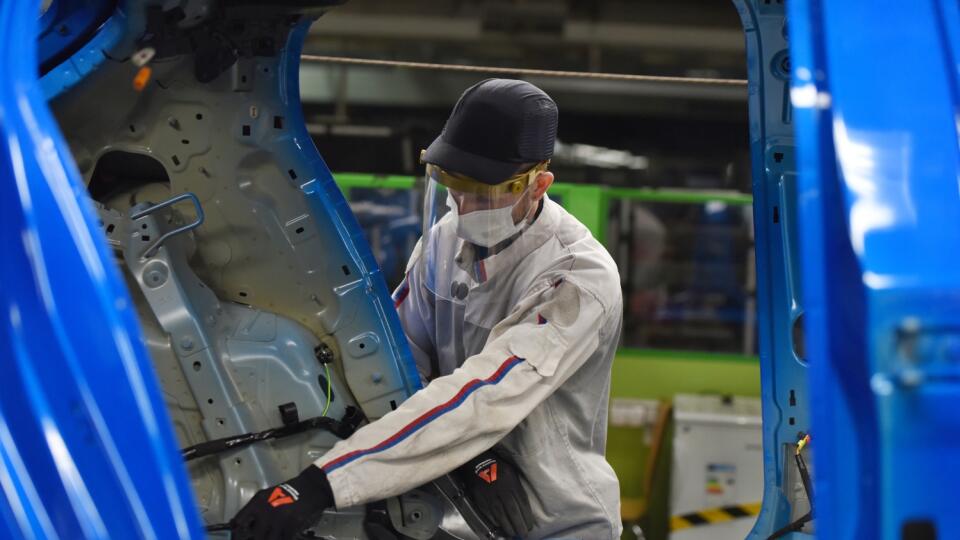 Trnavská automobilka Groupe PSA Slovakia nevyrába kvôli pandémii nového koronavírusu od 19. marca 2020. Počas odstávky výroby zriadili na pracovisku viacero sanitárnych opatrení. Na snímke zamestnance automobilky s ochranným rúškom a štítom počas prezentácie nových sanitárnych opatrení v trnavskej automobilke Groupe PSA Slovakia v Trnave v piatok 17. apríla 2020. FOTO TASR - Lukáš Grinaj